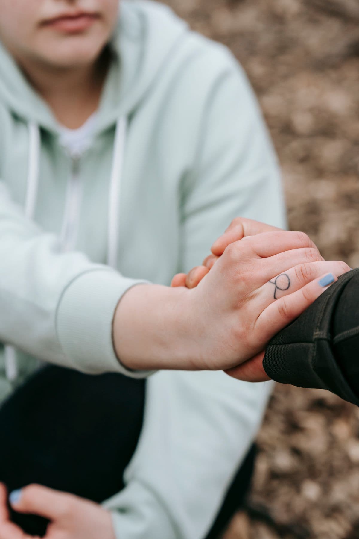 Duas mãos a segurarem-se em gesto de apoio e proximidade